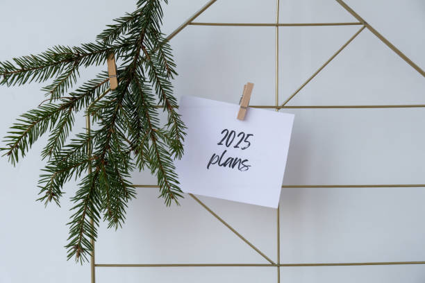 istock 2025 PLANS text on white paper note on vision board with Christmas decor. New year aims resolutions. New me you concept visualizing 2149465029