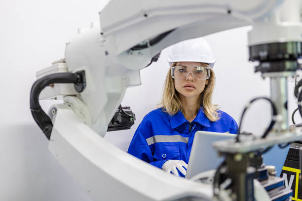 istock female technician engineer using laptop checking automation robotics at industrial modern factory. woman working at factory innovation automation robot. 2149465558
