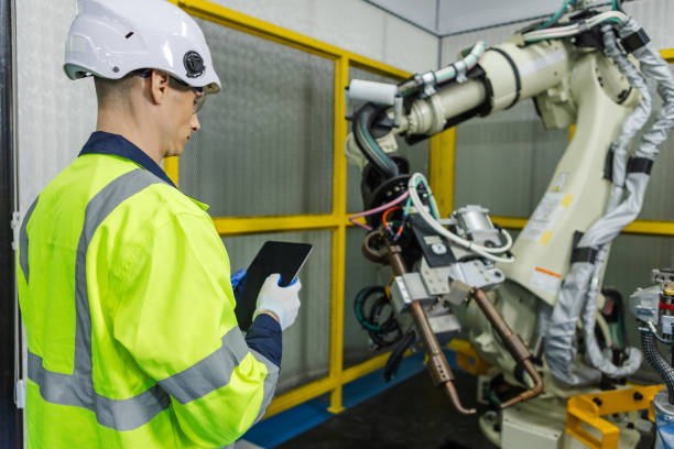 istock Man technician engineer using tablet control automation robotics at industrial modern factory. Male worker checking automation robot at factory innovation. 2149465616