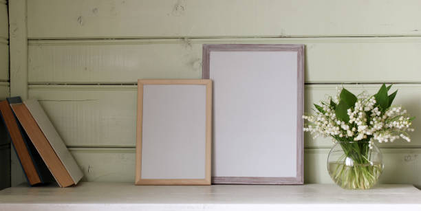istock two empty frames on the table and lilies of the valley, a rural mockup. copy space. 2149466757