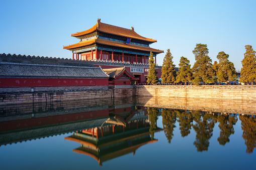 The Gate of Divine Prowess is also the north gate of  Forbidden City. The photo shows the gate is covered by golden sunlight in the morning with reflection on still water in the moat surrounded the Forbidden City.