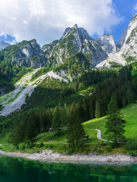 Sunny idyllic colorful summer alpine view. Lake Vorderer Gosausee is a peaceful mountain lake with clear transparent water and reflections. It's one of the three Gosausee lakes out there