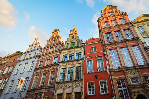 Facade of beautiful typical colorful houses on Dluga street (Dlugi Targ square) in old historical town centre at sunset. Gdansk, Poland