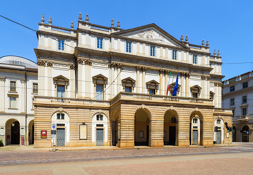 Milan, Italy - June 24, 2023: General view of the neoclassical facade of La Scala opera house (Teatro alla Scala), a world famous theater in the historic center of Milano, Italy on a sunny summer day