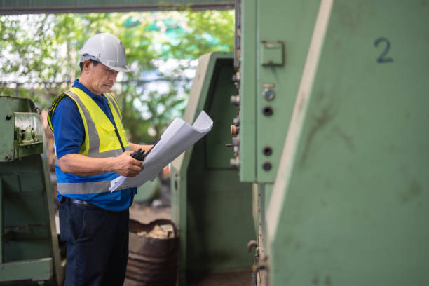 istock Senior Engineer Analyzes Blueprint for Machine Maintenance in Industrial Factory Setting 2149485730