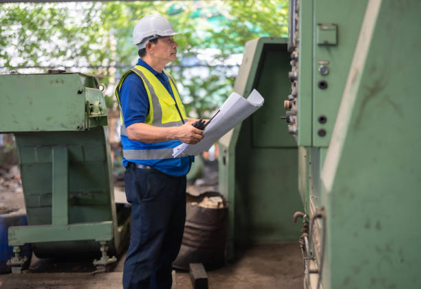 istock Senior Engineer Analyzes Blueprint for Machine Maintenance in Industrial Factory Setting 2149485902