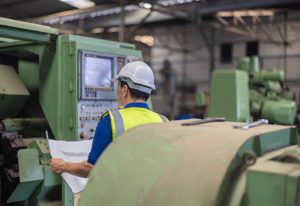 istock Senior Engineer Analyzes Blueprint for Machine Maintenance in Industrial Factory Setting 2149486027