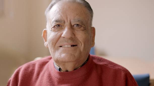 istock Old man smiling at camera sitting in nursing home 2149486548
