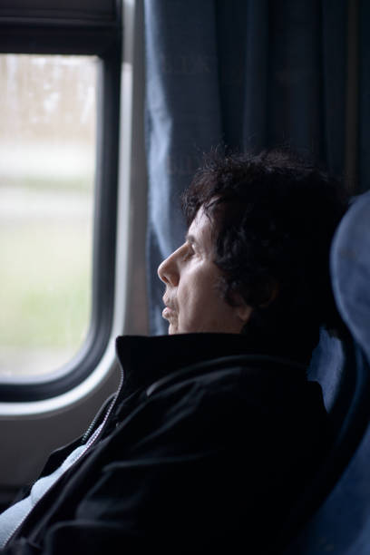 istock Pensive Elderly Lady Gazing Out Train Window 2149490296