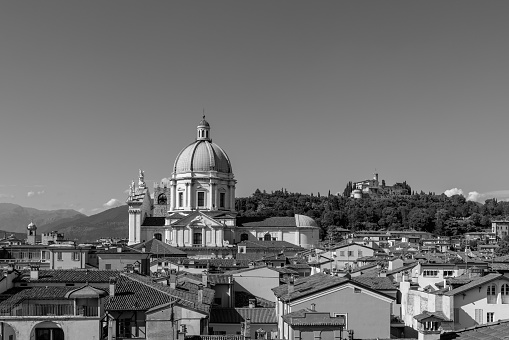 Vintage black and white photo of historic heart of Brescia, the Cathedral dome commanding the skyline while a medieval castle watches over from its hilltop perch