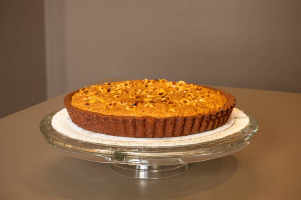 istock A rich chocolate tart with a luscious hazelnut cream topping is elegantly displayed on a raised glass stand, promising a decadent treat 2149491048
