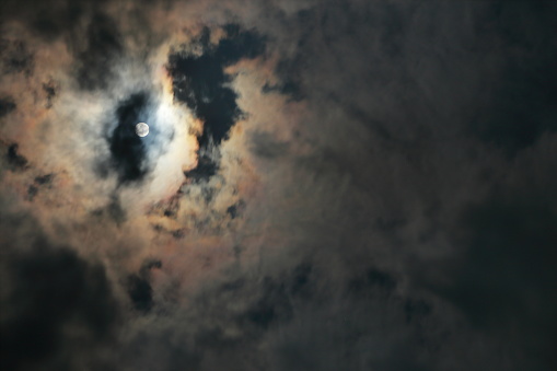the moon behind dramatic cloudy