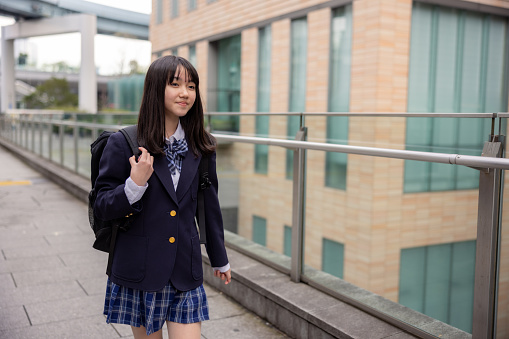 Teenage girl walking in city after school