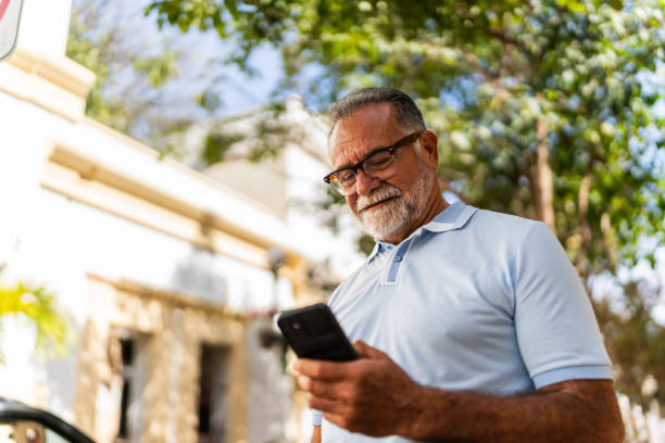 istock Senior man walking and using mobile phone outdoors 2149500030