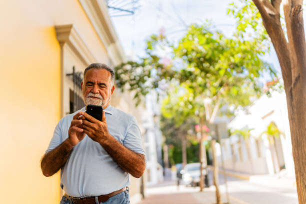 istock Senior man walking and using mobile phone outdoors 2149500065