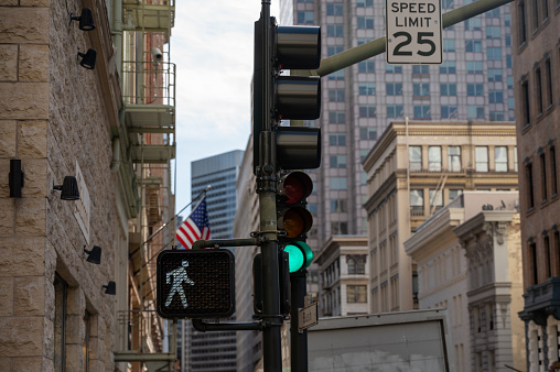 Pedestrian crossing light signal showing the white man icon to say ok to walk, in San Francisco during springtime day