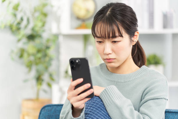 istock A woman looking at her smartphone with a serious expression 2149502890