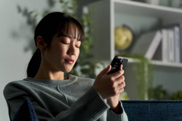 istock Woman closing her eyes while looking at smartphone 2149502913