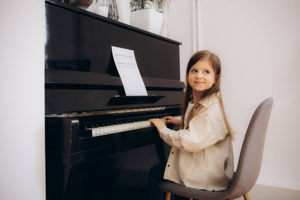 istock Little girl playing piano indoors 2149506183