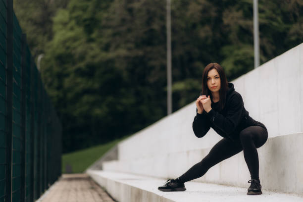 istock A fit sportswoman is stretching her legs on railing while warming up on the stairs. 2149506460