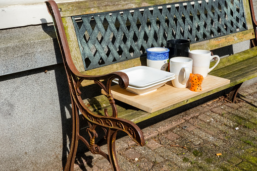 Typical scene along an Amsterdam canal, a bench in front of the house with mugs and plates ready for serving some coffee and food.