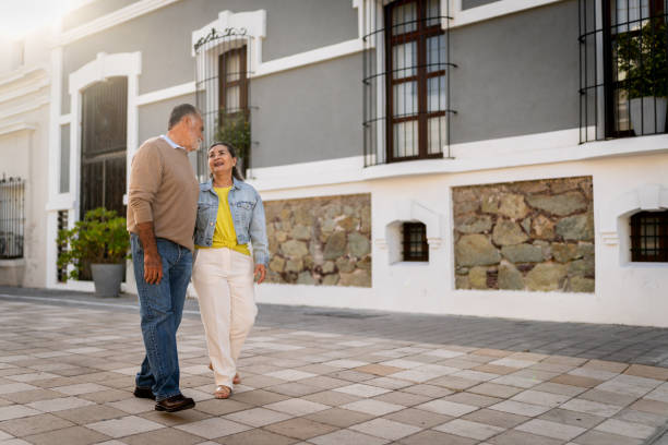 istock Senior couple talking and walking through the city 2149509660