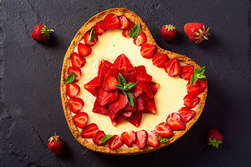Baked Strawberry cheesecake New York with mint. Heart form. Homemade dessert top view
