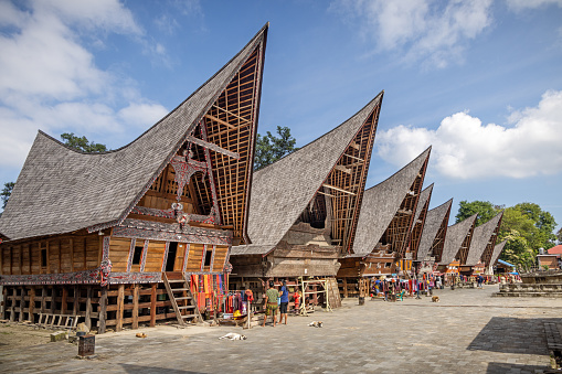Panguruan, North Sumatra, Indonesia - January 31th 2024:  Row of houses with a typical Batak roofs in a village which specialize in selling homemade scarfs to the tourists