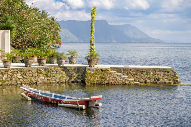 Lake Toba, North Sumatra, Indonesia - January 30th 2024:   Canoe made of a tree log laying at the shore of the large volcanic lake