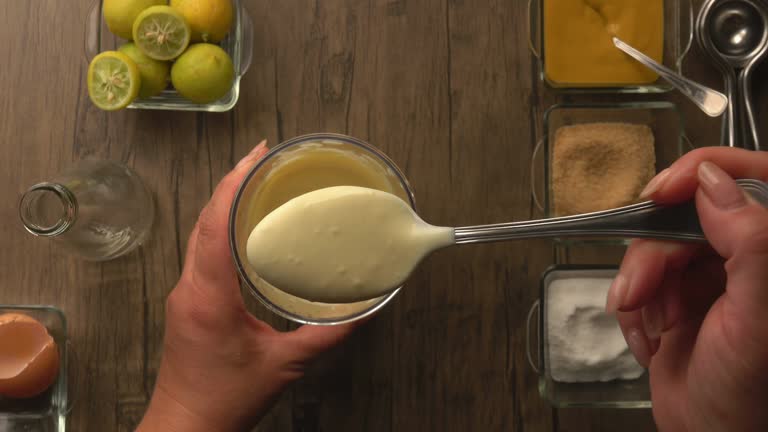 Spoon scooping up homemade mayonnaise and lifting it up