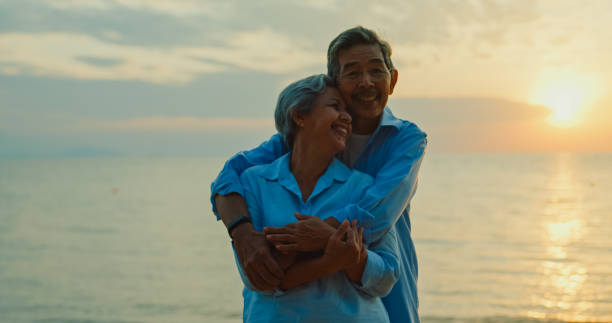istock Asian elderly cheerful couple smiling happily while embracing and looking at camera on beach enjoying the sea view. A happy senior adult people enjoy the travel lifestyle after retirement. 2149520529
