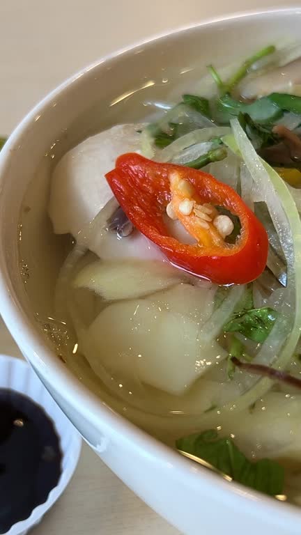 Pho Bo traditional Soup with beef, rice noodles, ginger, lime, chili pepper in bowl. Close up. Vietnamese and Asian cuisine.