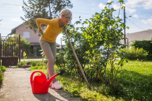 Senior woman having pain in her back while gardening