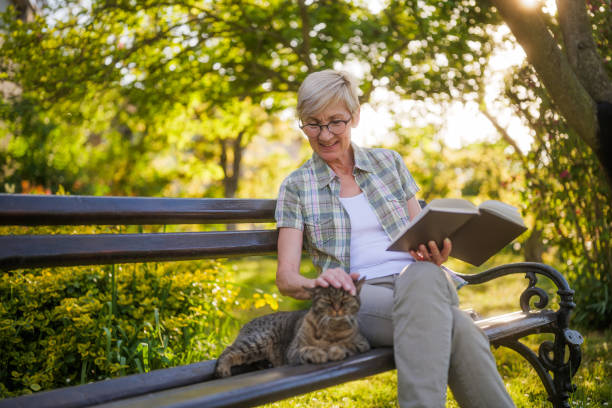 istock Senior woman reading book and spending time with her cat 2149521603