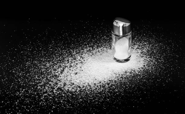 istock Scattered salt and a standing salt shaker 2149525751