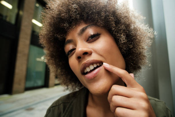 Curly woman pointing her lips outdoors.
