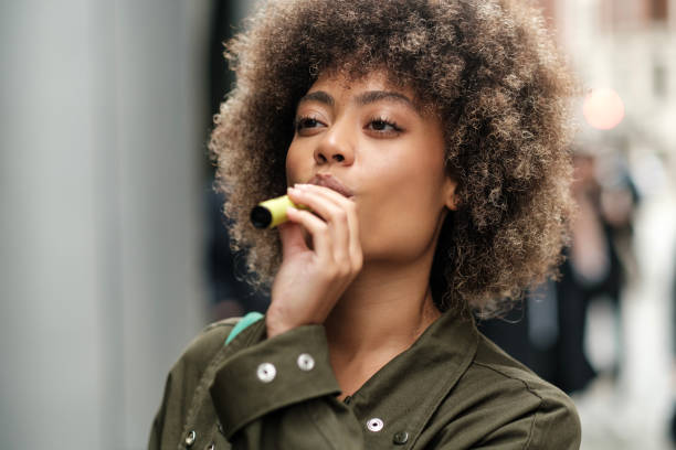 istock Attractive woman taking a drag from a e-cigarette. 2149525849