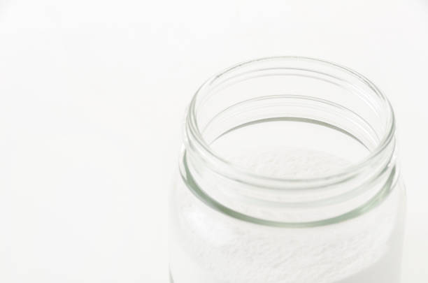 Glass jar of baking soda on white  background