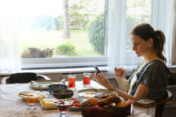 istock Woman using her phone at the breakfast table at home 2149527319