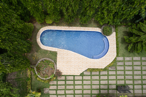 Empty swimming pool above top view in house backyard