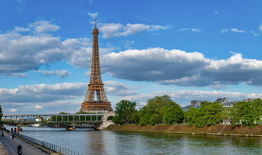 The Eiffel Tower in Paris under a nicely partly clouded blue sky