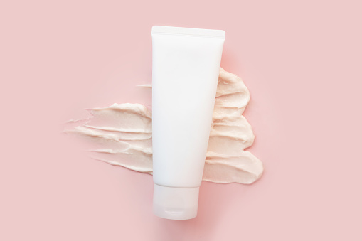 cosmetic cream tube bottle, big smear of moisturizer on pink background. moisturizing cream body skincare, shampoo, lotion, balsam sunscreen. Cosmetic skin care product blank package, template mockup