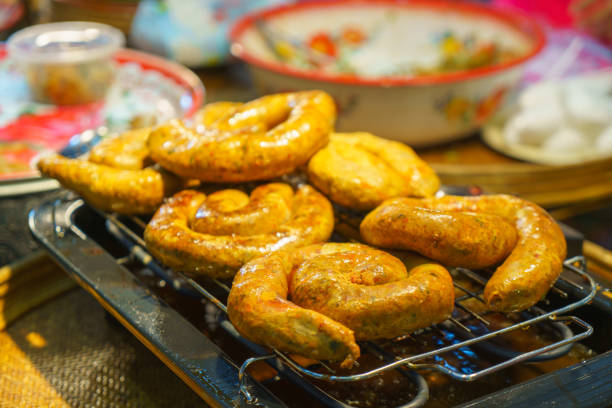 ndulge in the flavors of Northern Thailand with this savory delight! Aromatic grilled sausages, renowned for their unique blend of spices and rich flavors, are skillfully presented on a rack, enticing with their tantalizing aroma and inviting appearance