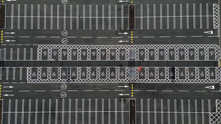Drone view ascending over a new supermarket car park with disabled parking bays.