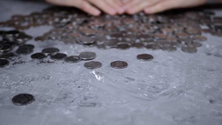 Greedy Female Hands are Raking up a Pile of Scattered Ukrainian Coins on Table