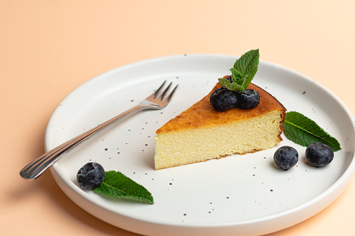 Cheesecake Slice On Plate With Blueberries, Pink Background.