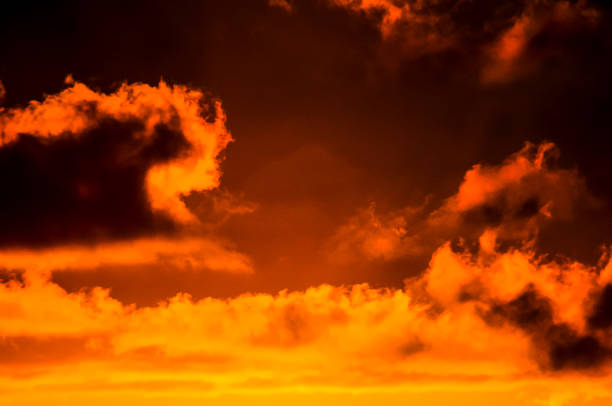 The sky is orange and cloudy. The clouds are dark and the sky is a deep shade of orange