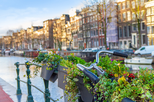 Cityscape - view of a parked bicycle close-up against the backdrop of a water channel in the historic center of Amsterdam, the Netherlands