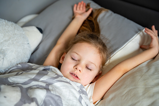 Cute little girl sleeping and grinding teeth in dreams, clenched teeth with tiredness and stress. High quality photo