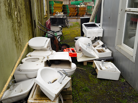 Old basins and toilet pans at scrap compound UK